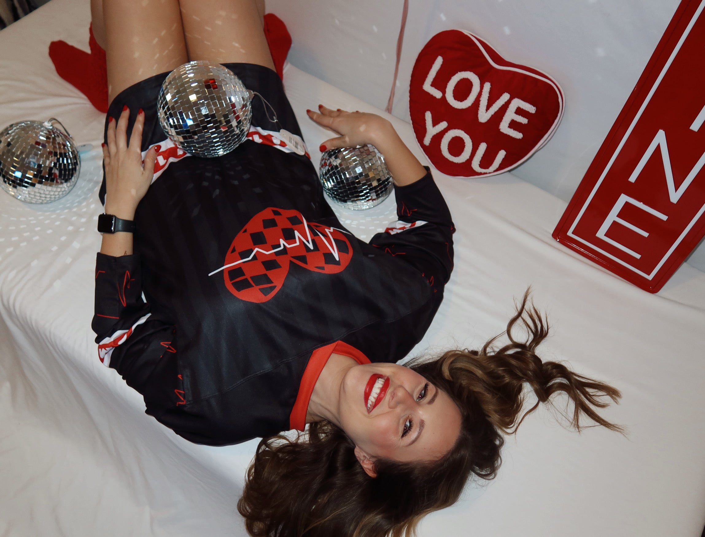 Model is wearing a red and black dubstep rave hockey jersey in a size L for the Sweet Bass Valentine's Collection. 