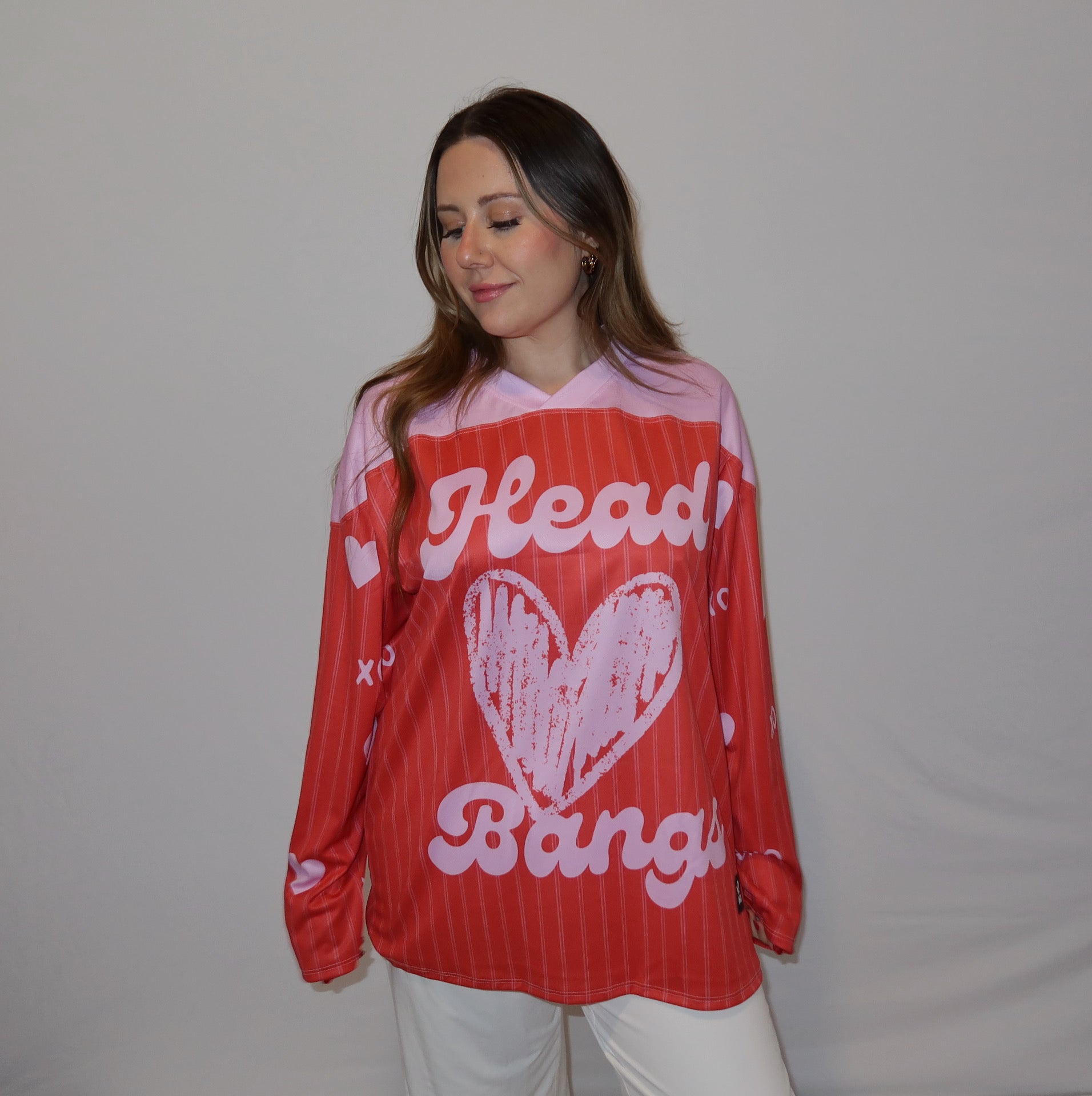 Person wearing red and pink head banger rave hockey jersey.