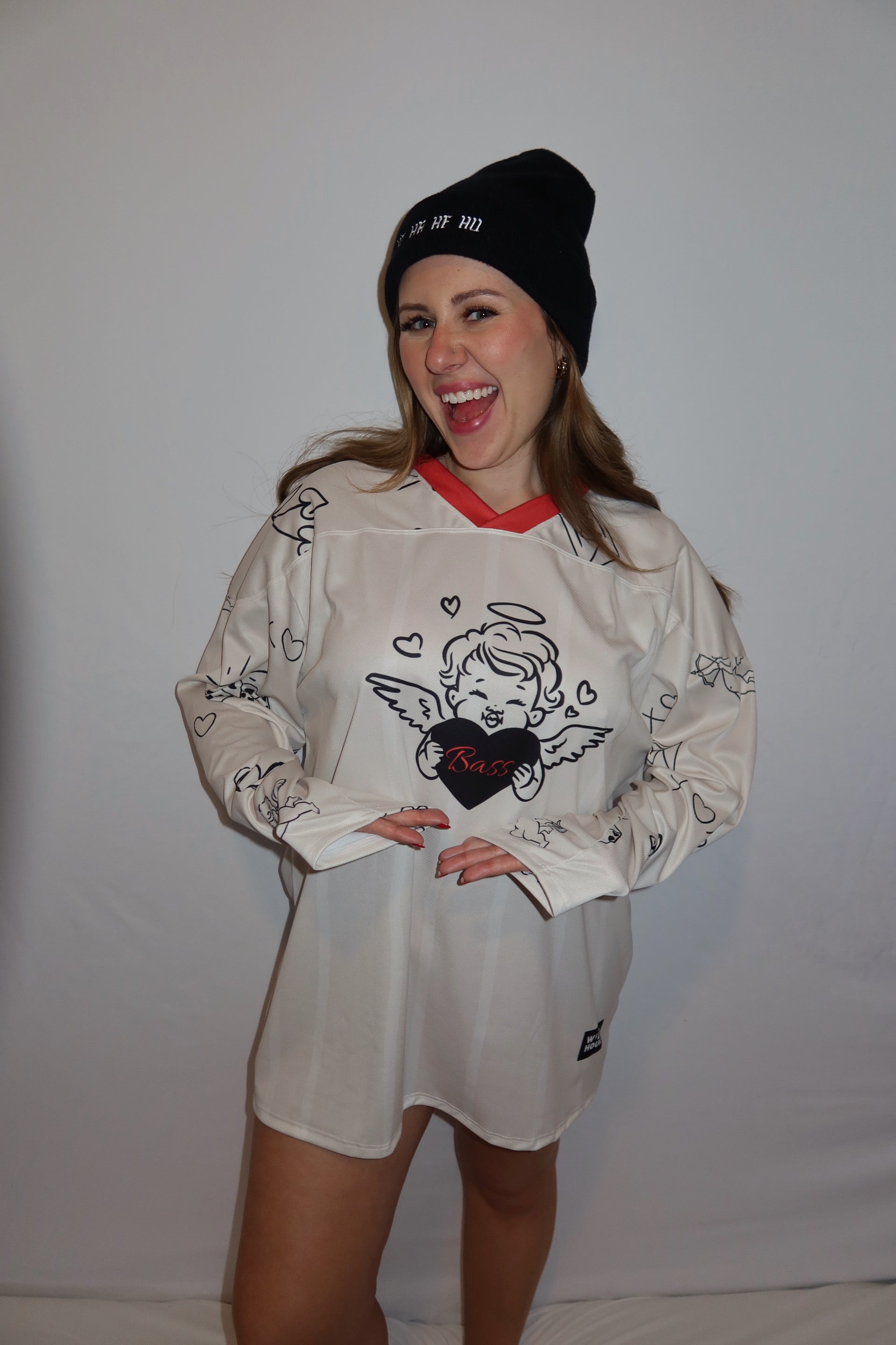 Person pointing at the front of a bass angel jersey.